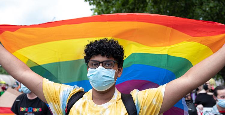 Young person carrying a rainbow flag