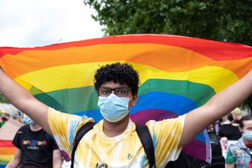 Young person carrying a rainbow flag